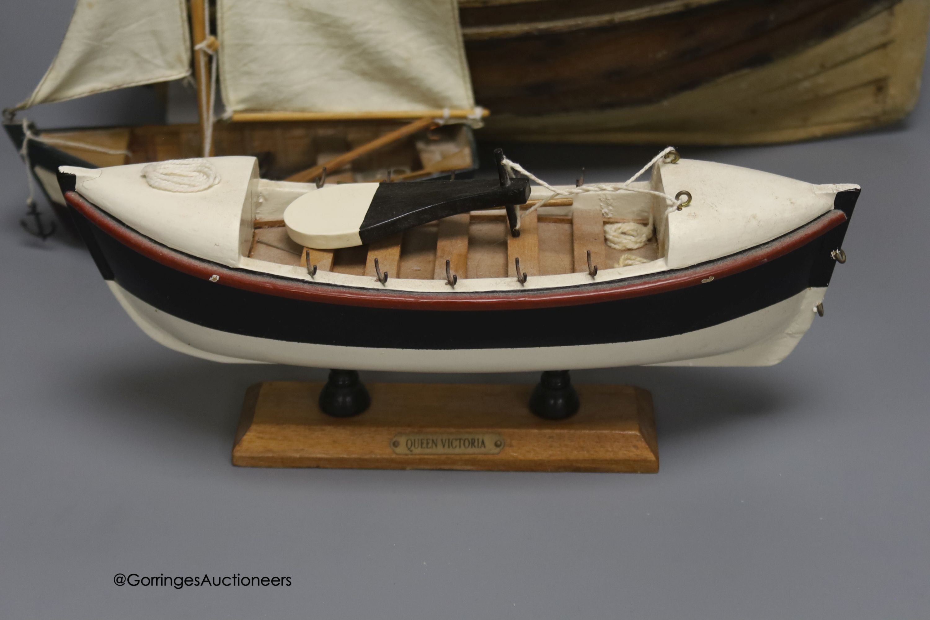 A clinker-built wood rowing boat, 41cm, and four smaller boat models